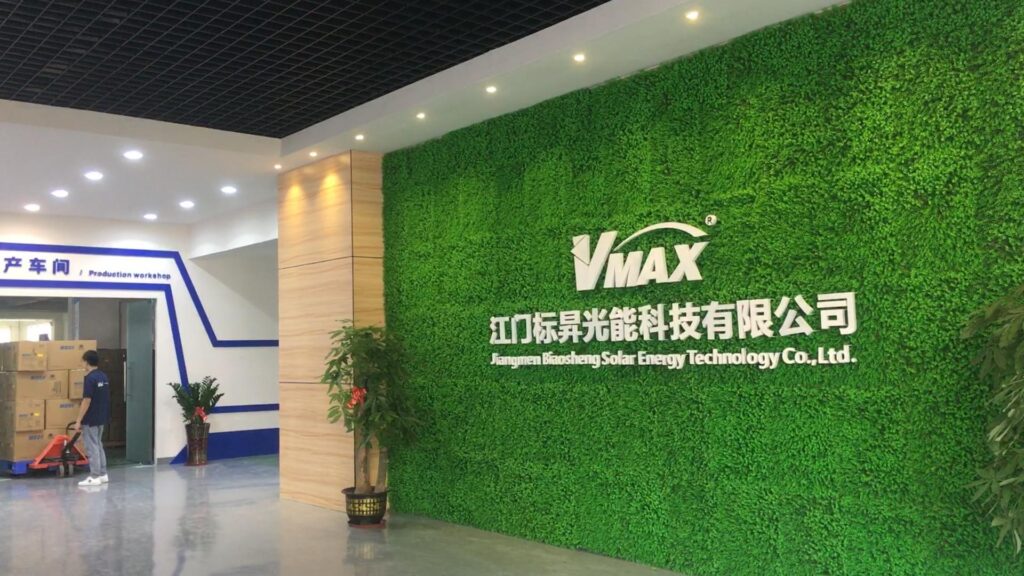 About US Reception area of Jiangmen Biaosheng Solar Energy Technology, showing the green logo wall and entrance to the production workshop.